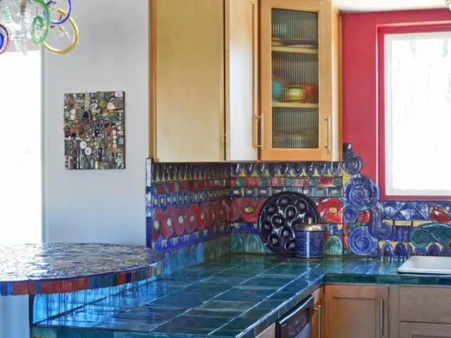 very bold teal tiles on the countertops and red and blue tiles on the backsplash