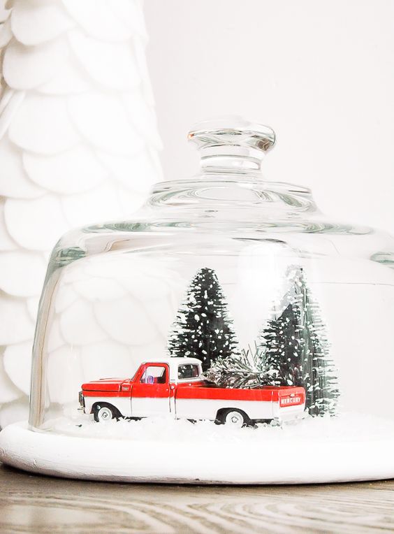 vintage snow globe with a pick up and tiny trees