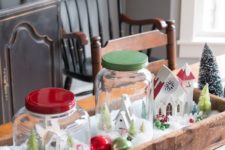 25 a wooden crate with jar snow globes and ornaments as a centerpiece