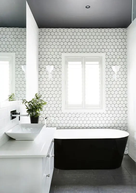 dark grey floors, a dark ceiling and white hex tiles with black grout to tie everything up
