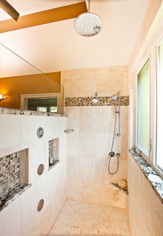 Warm and light colored walk in shower with accentuated niches