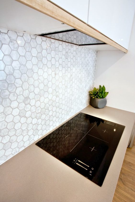 neutral mother of pearl hex tile backsplash for a modern kitchen