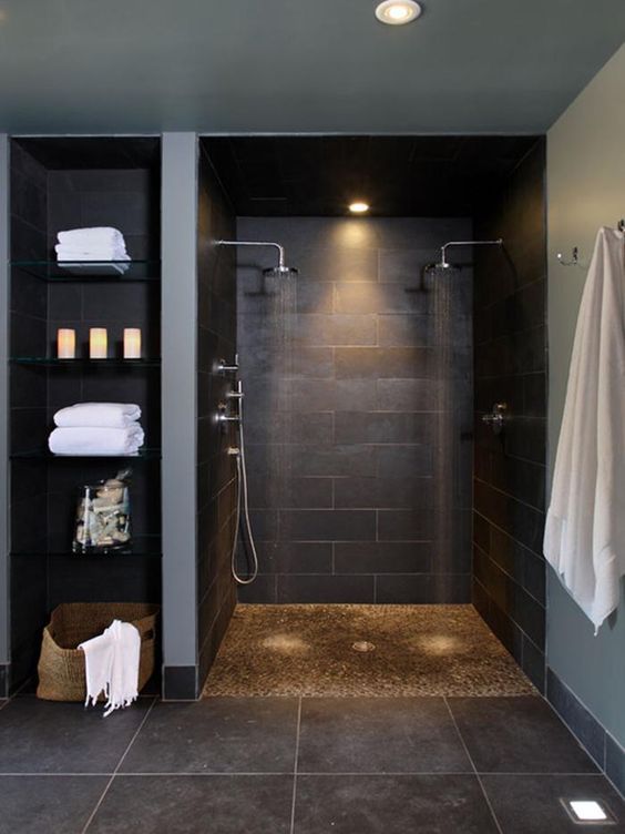 dark-colored basement walk-in shower and glass shelves on the side