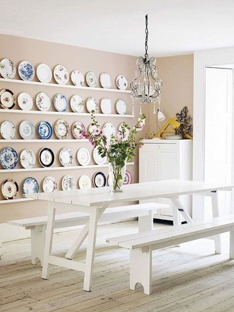 white picnic furniture and colorful platters on the wall