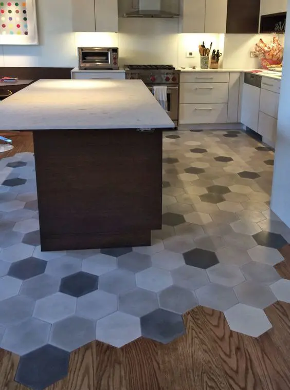 hardwood floors and grey mosaic hex tiles to separate a kitchen zone and a dining zone