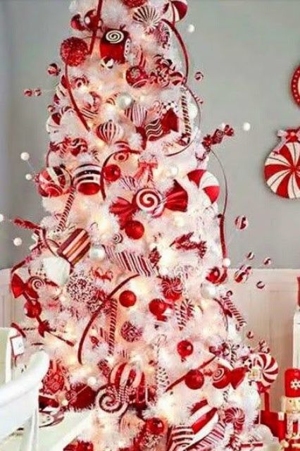 white tree with red ornaments and candy swirls