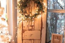 35 shabby chic door inside the house with a lit up wreath of greenery