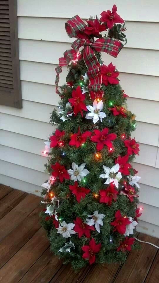small tomato cage Christmas tree with red and white poinsettia flowers