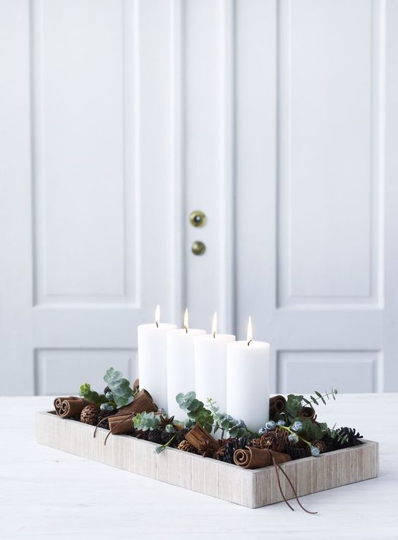 modern Christmas display in a wooden tray, with cinnamon sticks, eucalyptus and candles