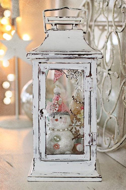 whitewashed lantern with a tiny bottle brush tree and a snowman inside