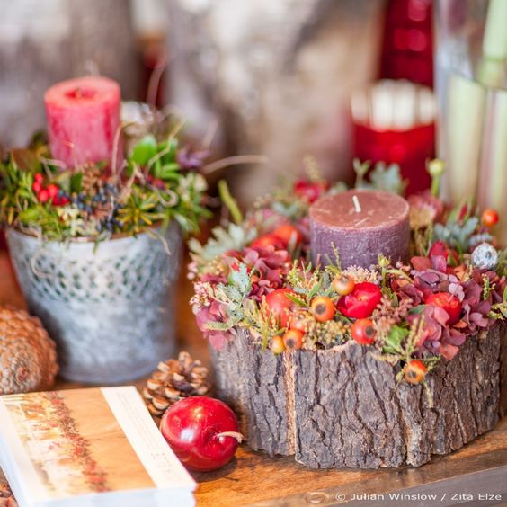 wooden log with a candle, flowers and berries