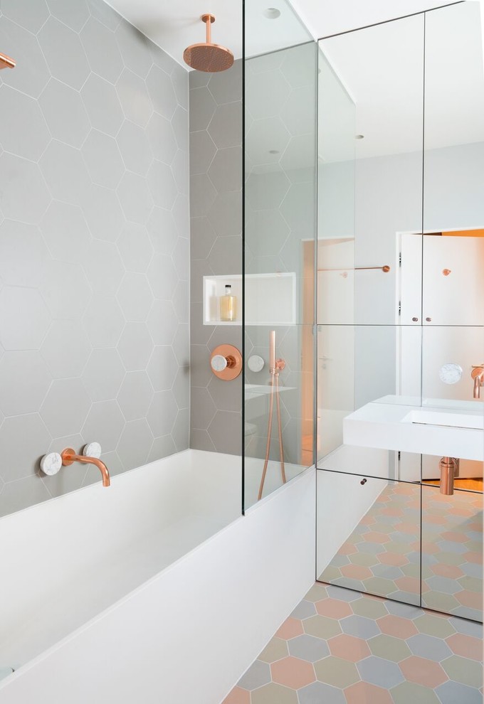 Pastel tones of floor tiles mixed with copper fittings makes this bathroom quite unique. Mirrored panelled cabinets not only provide storage space but also visually enlarge the space. (Amberth)