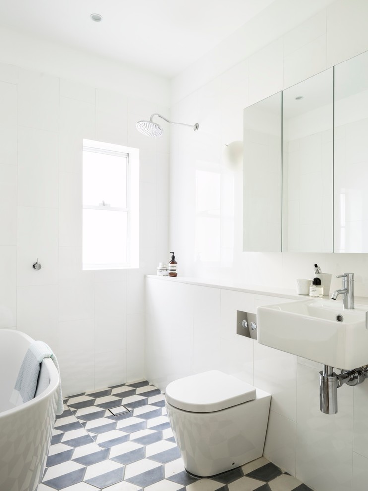 interesting half white half black hex tiles create interesting pattern in otherwise pure white bathroom (Decus Interiors)