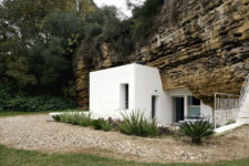 02 White plaster house architecture looks spotless next to discolored rock and there’s a lot of greenery around