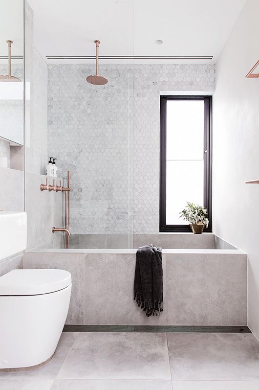 rectangular concrete bathtub looks great with marble tiles