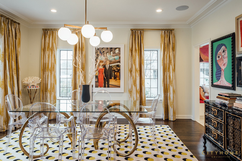 The dining space strikes with unique artworks and a horn legged dining table with a glass top