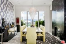 04 The dining area in black and white boasts of sunny yellow dining set and a glam chandelier