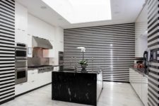 05 The kitchen is done in black and white stripes, with white drawers and a black marble kitchen island