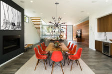06 The dining room is decorated with red chairs, cool wall art and a statement chandelier