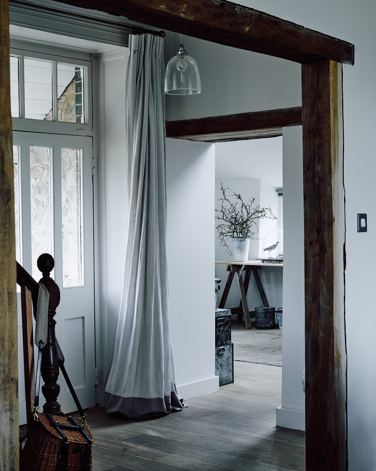 Wooden beams, shabby grey floors, baskets and those ethereal textiles add charm to the decor
