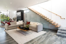 07 The floors are covered with grey and beige tiles, and the staircase is exciting, of wood and glass, looks very modern