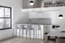 09 The kitchen is small and neutral, done in white and light grey, with a kitchen island as a breakfast nook