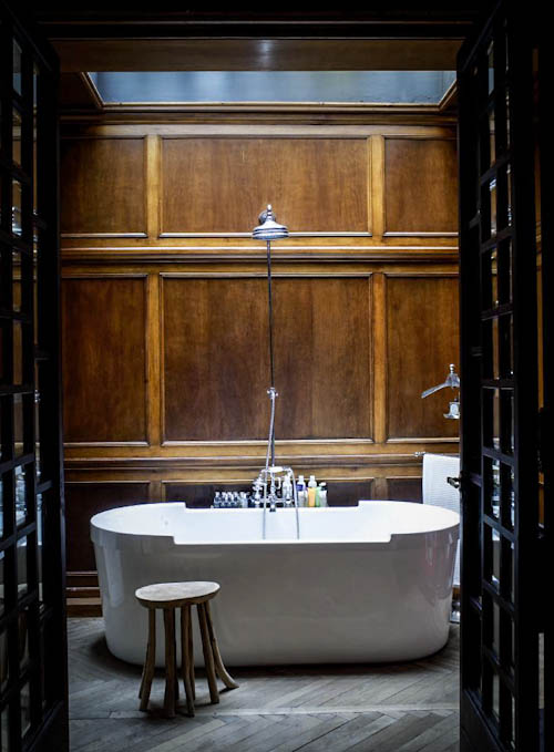 The bathroom looks breathtaking - only oak panels, ash grey wooden floors and a free-standing bathtub