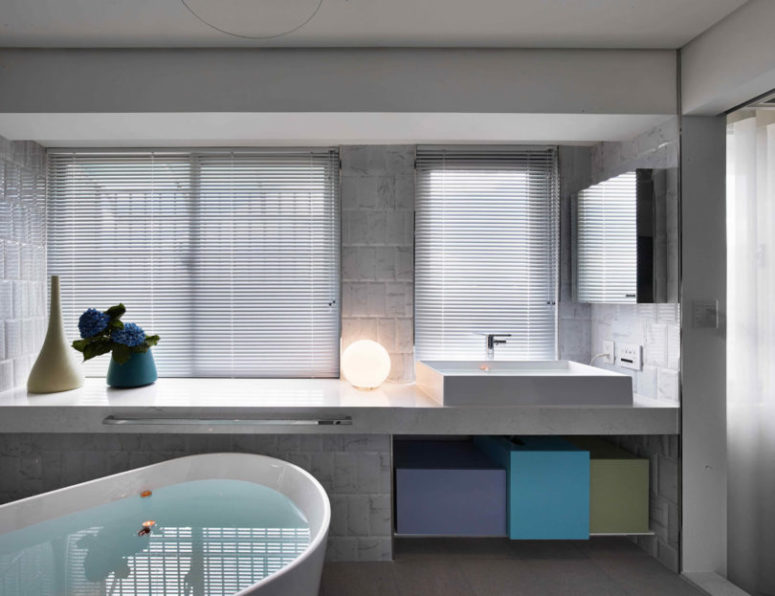 Master bathroom is clean and simple, with colorful geometric boxes for storage