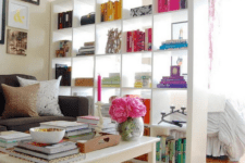12 a tall shelving unit separates a bedroom zone from the living room