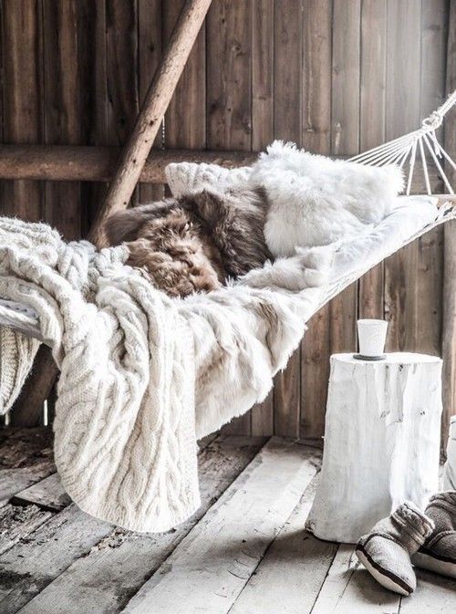 hammock with fur pillows and a cable knit blanket