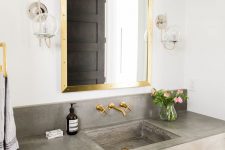 17 brass mirror frame and faucets add a glam feel to this bathroom