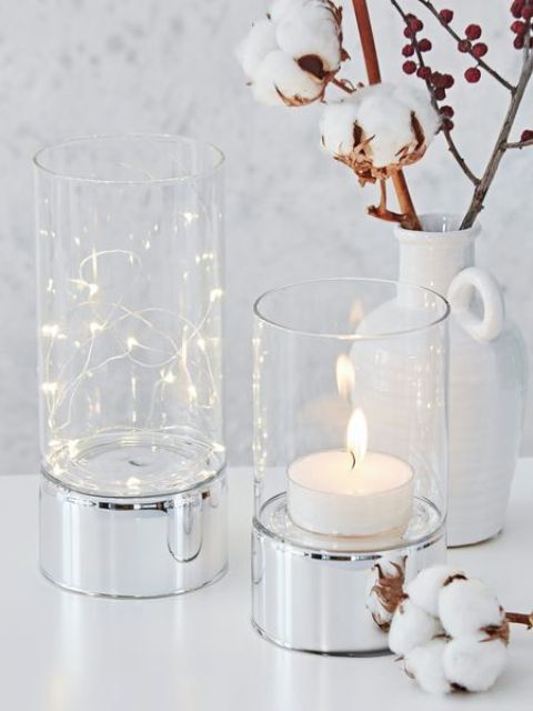 clear glass hurricanes with silver bases can add a cool touch to any decor