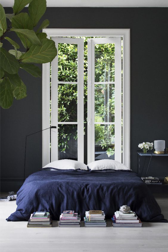 indigo bedspead in a dark and moody bedroom is a nice idea