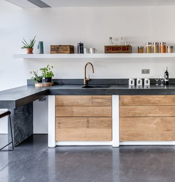 Dark concrete countertop contrasts with light colored woods