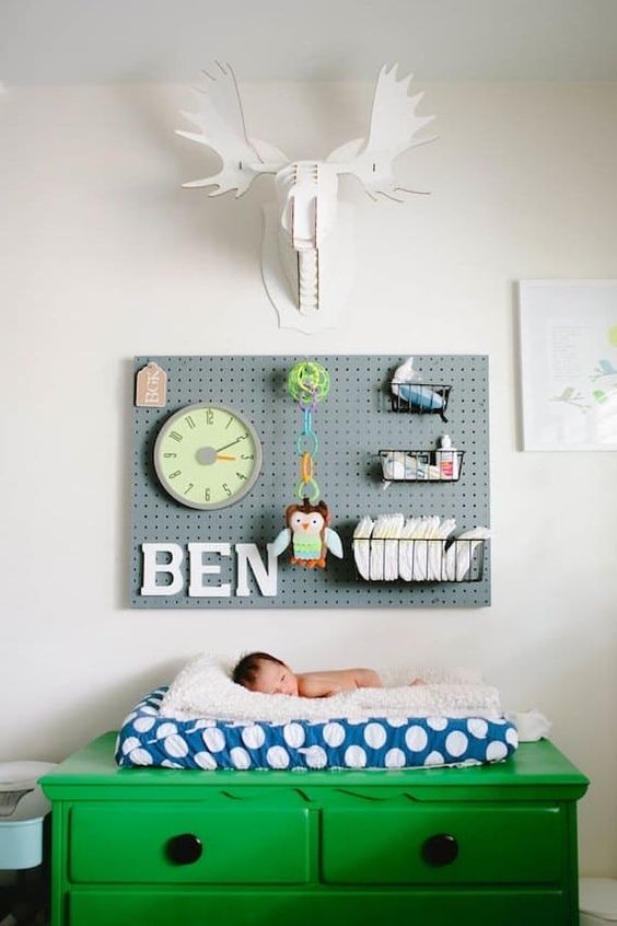 a pegboard in a nursery over the diaper changing station is a very practical solution