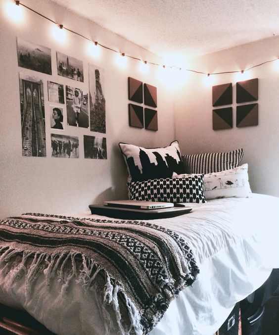 rather a neutral room with boho blankets, black and white pictures