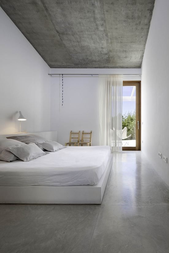 pure white bedroom with an accent concrete ceiling