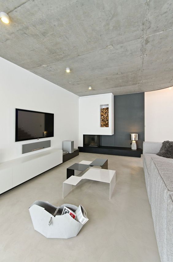 minimalist living room with a concrete ceiling and white walls