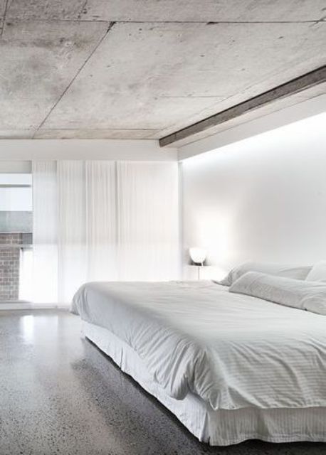 minimalist bedroom with polished concrete floors and a concrete ceiling