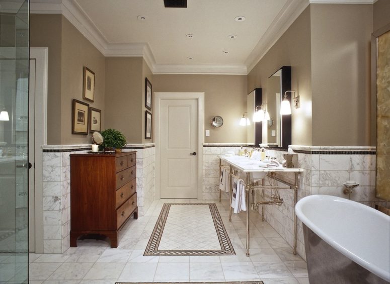 Taupe walls with marble flooring and wainscoting make this bathroom looks neutral yet luxurious. (William W. Stubbs and Associates)