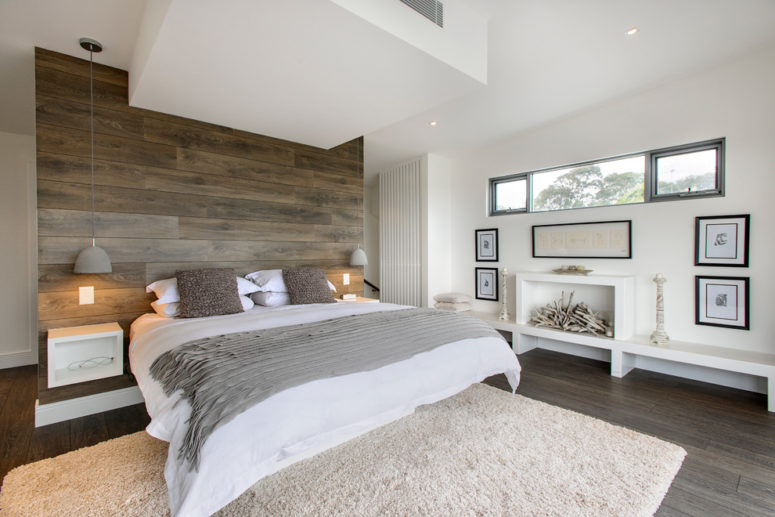A reclaimed wood wall in natural tones is a chic addition to a neutral bedroom design that features dark and light taupe shades. (CAPITAL BUILDING)