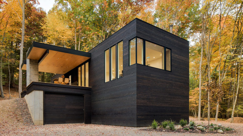 This forest cabin in blackened wood was built for a car lover owner