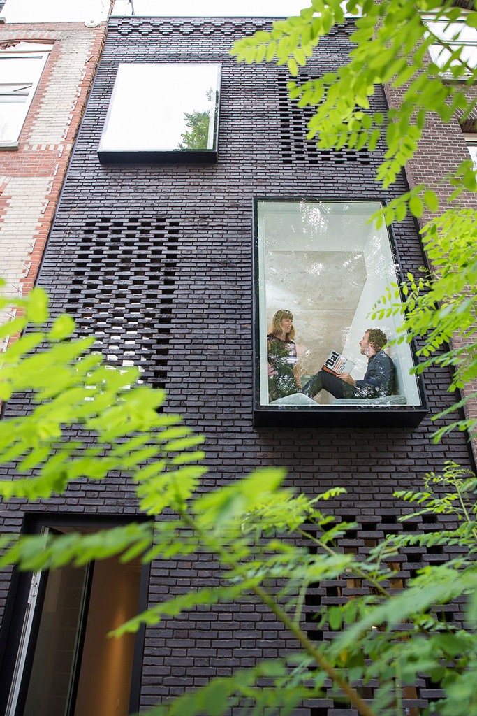 This modern black brick house is tightened between two old residences and was built by two architects for themselves