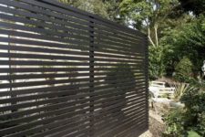 02 a black wooden fence can make a stylish statement in your backyard