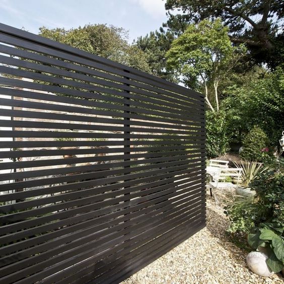 a black wooden fence can make a stylish statement in your backyard