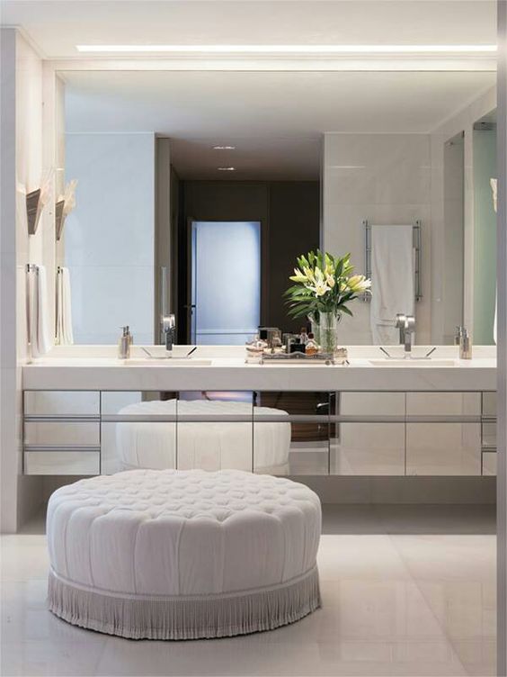 a mirror wall, mirrored cabinets and white statuary marble on the wall and on the floor