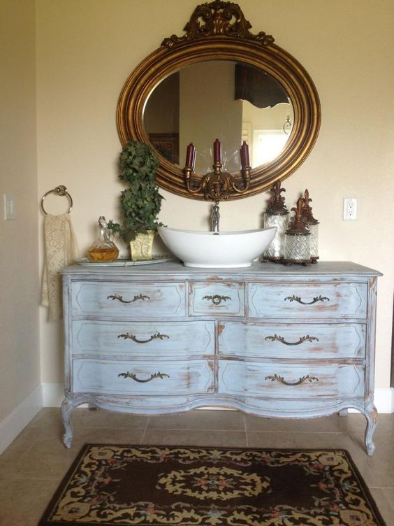 an old dresser was whitewashed and repurposed into a bathroom cabinet