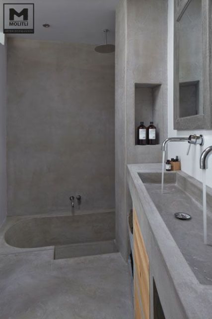 an all-concrete bathroom with the same vanity and wooden details