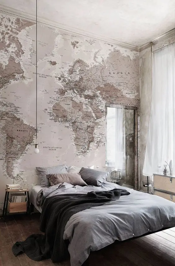 Industrial bedroom design with a headboard wall covered with a world map.