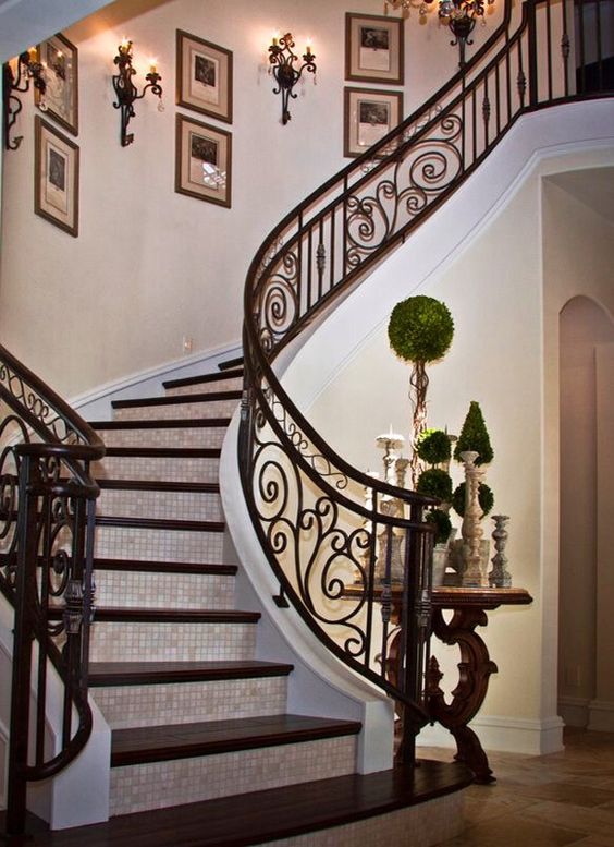 Stunning indoor staircase of dark wood and custom made wrought iron decor